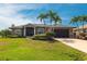 Front exterior showcasing lush landscaping, two-car garage, and meticulous lawn of a single-Gathering home at 17150 Sarong Ln, Punta Gorda, FL 33955