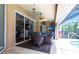 Covered outdoor patio with comfortable seating, ceiling fan, and sliding door access to the pool at 17150 Sarong Ln, Punta Gorda, FL 33955