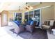 Inviting covered patio with wicker seating, ceiling fan, and sliding glass doors, perfect for outdoor relaxation at 17150 Sarong Ln, Punta Gorda, FL 33955