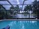 Relaxing pool area featuring a screened enclosure and serene water views with palm trees at 17150 Sarong Ln, Punta Gorda, FL 33955