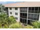 Exterior of building featuring screened in lanais surrounded by lush tropical landscaping at 175 Kings Hwy # 625, Punta Gorda, FL 33983