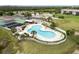 Aerial view of community pool with lounge chairs and palm trees, surrounded by a white picket fence at 175 Kings Hwy # 625, Punta Gorda, FL 33983