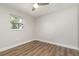 Neutral bedroom with wood-look floors, window with tree view, and ample space at 18178 Wolbrette Cir, Port Charlotte, FL 33948