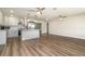 Open kitchen and living room featuring modern appliances, an island, and wood-look flooring at 18178 Wolbrette Cir, Port Charlotte, FL 33948