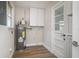 Functional laundry room boasts modern water heater, cabinet storage, and wood-look flooring at 18178 Wolbrette Cir, Port Charlotte, FL 33948