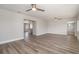 Spacious living room boasts wood-look flooring, ceiling fan, and open access to kitchen at 18178 Wolbrette Cir, Port Charlotte, FL 33948