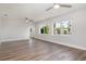 Bright living room with wood-look floors, ceiling fans, and natural light from large windows at 18178 Wolbrette Cir, Port Charlotte, FL 33948