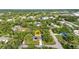 A bird's-eye view of the property showcasing the home, pool, lush greenery, neighborhood, and tree coverage at 2031 Backton St, Port Charlotte, FL 33948