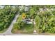 Aerial view of home and pool highlighting the landscaped yard, neighborhood, and surrounding lush tree canopy at 2031 Backton St, Port Charlotte, FL 33948