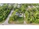 Aerial view of a home with solar panels and a refreshing backyard pool, surrounded by lush greenery and mature trees at 2031 Backton St, Port Charlotte, FL 33948