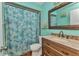 Charming bathroom with turquoise walls, a patterned shower curtain, and a vanity with a wooden base at 2031 Backton St, Port Charlotte, FL 33948