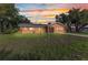 Exterior view of a home with lawn and sky at sunset at 2031 Backton St, Port Charlotte, FL 33948