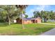 Charming single-story home featuring solar panels, an orange exterior, and well-maintained landscaping at 2031 Backton St, Port Charlotte, FL 33948