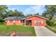 Charming coral-colored home featuring a well-manicured lawn, solar panels, and a concrete driveway at 2031 Backton St, Port Charlotte, FL 33948