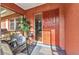 Front porch features a chair, plant, and red door at 2031 Backton St, Port Charlotte, FL 33948