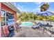 The backyard pool has patio seating, an umbrella, and a privacy fence at 2031 Backton St, Port Charlotte, FL 33948