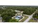 An elevated shot of a cozy home with a pristine pool enveloped by lush greenery at 21220 Pemberton Ave, Port Charlotte, FL 33952