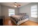 Bedroom with wood floor, queen bed with patterned bedding, a ceiling fan, and windows with blinds at 21220 Pemberton Ave, Port Charlotte, FL 33952