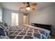 Bedroom with wood floor, queen bed with patterned bedding, ceiling fan and bathroom access at 21220 Pemberton Ave, Port Charlotte, FL 33952