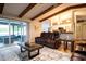 Spacious living room with hardwood floors, exposed beams, and comfortable leather seating, with a view of the patio at 21220 Pemberton Ave, Port Charlotte, FL 33952