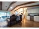 Open-concept living room with hardwood floors, exposed beams, and comfortable leather seating, open to the kitchen at 21220 Pemberton Ave, Port Charlotte, FL 33952