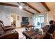 Cozy living room with hardwood floors, exposed beams, and a view of the bedroom and screened-in patio at 21220 Pemberton Ave, Port Charlotte, FL 33952