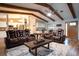 Inviting living room featuring exposed beams, hardwood floors, and comfortable leather seating at 21220 Pemberton Ave, Port Charlotte, FL 33952