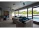 Relaxing screened patio with wicker furniture, ceiling fans, and a view of the sparkling pool and backyard at 21220 Pemberton Ave, Port Charlotte, FL 33952