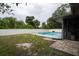 Backyard featuring a pool, privacy fence, lawn, and screened patio, ideal for outdoor living at 21220 Pemberton Ave, Port Charlotte, FL 33952
