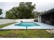 Backyard featuring a refreshing pool, privacy fence, and lush trees providing a serene retreat at 21220 Pemberton Ave, Port Charlotte, FL 33952