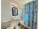 Bathroom with a pedestal sink, a blue patterned shower curtain, and neutral flooring at 21899 Cellini Ave, Port Charlotte, FL 33952