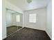 Bedroom features neutral carpet, a sliding mirror closet door, and two windows at 21899 Cellini Ave, Port Charlotte, FL 33952