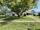 Charming single-story home featuring a carport and mature trees enhancing curb appeal at 21899 Cellini Ave, Port Charlotte, FL 33952