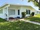 Inviting single-story home showing a front entryway with manicured landscaping and vibrant green grass at 21899 Cellini Ave, Port Charlotte, FL 33952