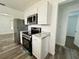 A kitchen area with white cabinets, stainless steel appliances, and granite countertops offering a modern design at 21899 Cellini Ave, Port Charlotte, FL 33952