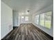 Spacious living room featuring wood-look flooring, bright windows, and fresh white walls at 21899 Cellini Ave, Port Charlotte, FL 33952