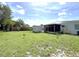 Extensive backyard with a shed, screened lanai, and lush lawn area, ideal for outdoor activities at 22334 Augusta Ave, Port Charlotte, FL 33952