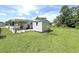 Well-maintained backyard with a shed, lush green lawn, and partial shade from mature trees at 22334 Augusta Ave, Port Charlotte, FL 33952