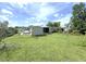 Spacious backyard featuring a shed, screened-in porch, and a mix of open lawn and shady areas at 22334 Augusta Ave, Port Charlotte, FL 33952