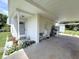 Covered carport featuring a bench, various potted plants, and direct access to a shed and the front door at 22334 Augusta Ave, Port Charlotte, FL 33952