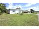 Quaint single-story home featuring a well-kept lawn, bright exterior, and a convenient carport at 22334 Augusta Ave, Port Charlotte, FL 33952