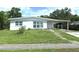 Charming single-story home with a well-maintained lawn, carport, and freshly painted exterior at 22334 Augusta Ave, Port Charlotte, FL 33952