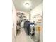Compact laundry room equipped with shelves, modern washer/dryer, and water heater at 22334 Augusta Ave, Port Charlotte, FL 33952