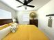 Well-lit bedroom with white walls, a ceiling fan, and a large bed covered in yellow bedding at 22334 Augusta Ave, Port Charlotte, FL 33952