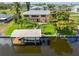 Aerial view of a house on a canal with a private boat dock and lift and lush green landscaping at 24398 Treasure Island Blvd, Punta Gorda, FL 33955