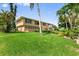 Backyard with a lush lawn on a canal featuring the back of the home with multiple windows for natural light at 24398 Treasure Island Blvd, Punta Gorda, FL 33955