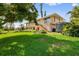 Spacious backyard with a beautiful green lawn and mature trees at 24398 Treasure Island Blvd, Punta Gorda, FL 33955