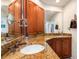 Bathroom featuring granite countertop, wood cabinetry and large mirrors at 24398 Treasure Island Blvd, Punta Gorda, FL 33955