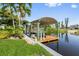 Exterior shot of the covered boat dock with lift on the canal with wood decking and room for entertaining at 24398 Treasure Island Blvd, Punta Gorda, FL 33955