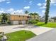 Exterior shot featuring a two-story home with a metal roof, a two-car garage, and a wide driveway at 24398 Treasure Island Blvd, Punta Gorda, FL 33955